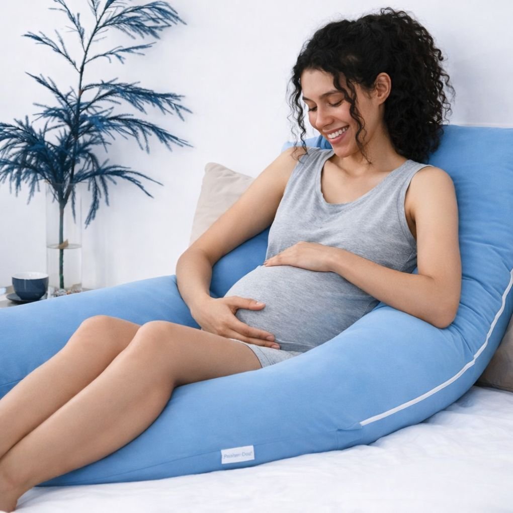 Pregnant woman resting with blue U-shaped pregnancy pillow for belly, back, and leg support