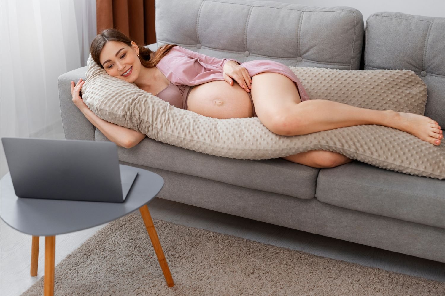 Pregnant woman sleeping with a U-shaped pregnancy pillow